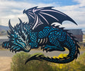Sleeping dragon epoxy resin window art with metallic blue scales and folded black wings, close-up